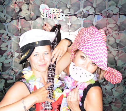 Zwei Kolleginen stehen in einer Fotobox und halten eine aufblasbare Guitarre in der Hand.